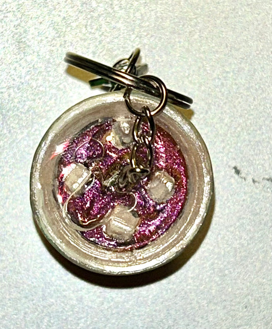 A green and white soda drink keychain with gold star (Top view)