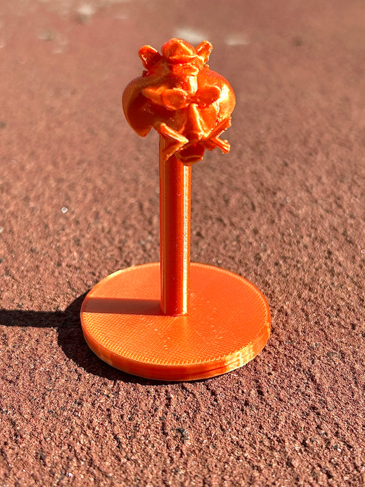 Orange Tiger figurine on a red surface outdoors