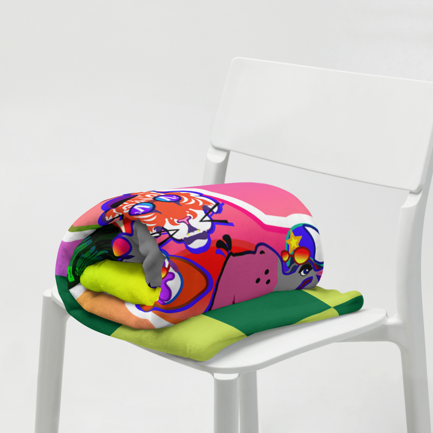 Rolled-up colorful blanket with cartoon characters on a white chair