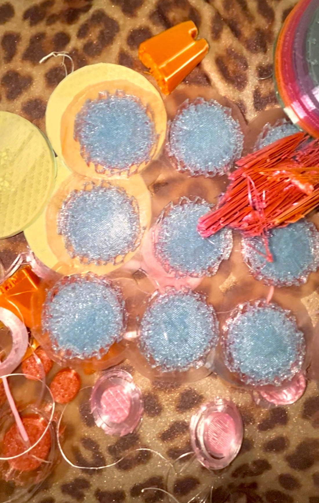 A pile of failed 3D prints of different shapes and meshes on jaguar-pattern background