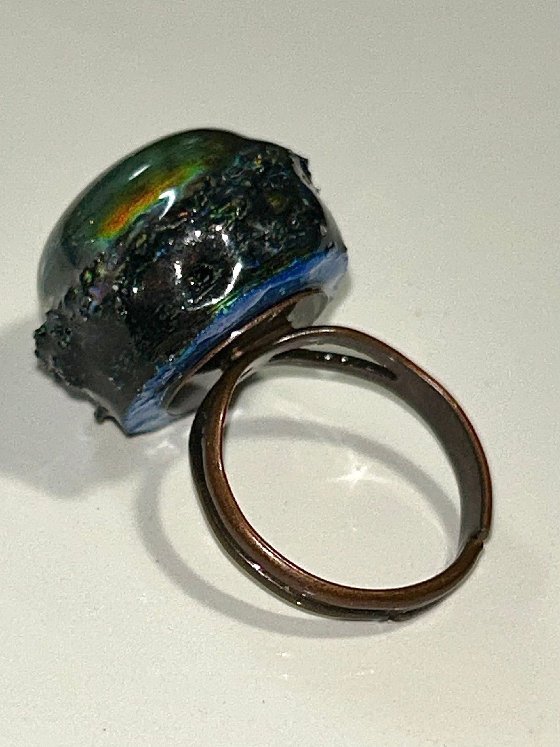 Bronze mood ring with a shiny, reflective surface on a white background