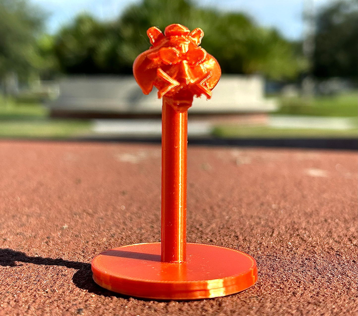 Orange Tiger figurine on a red surface outdoors