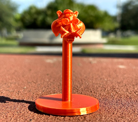 Orange Tiger figurine on a red surface outdoors