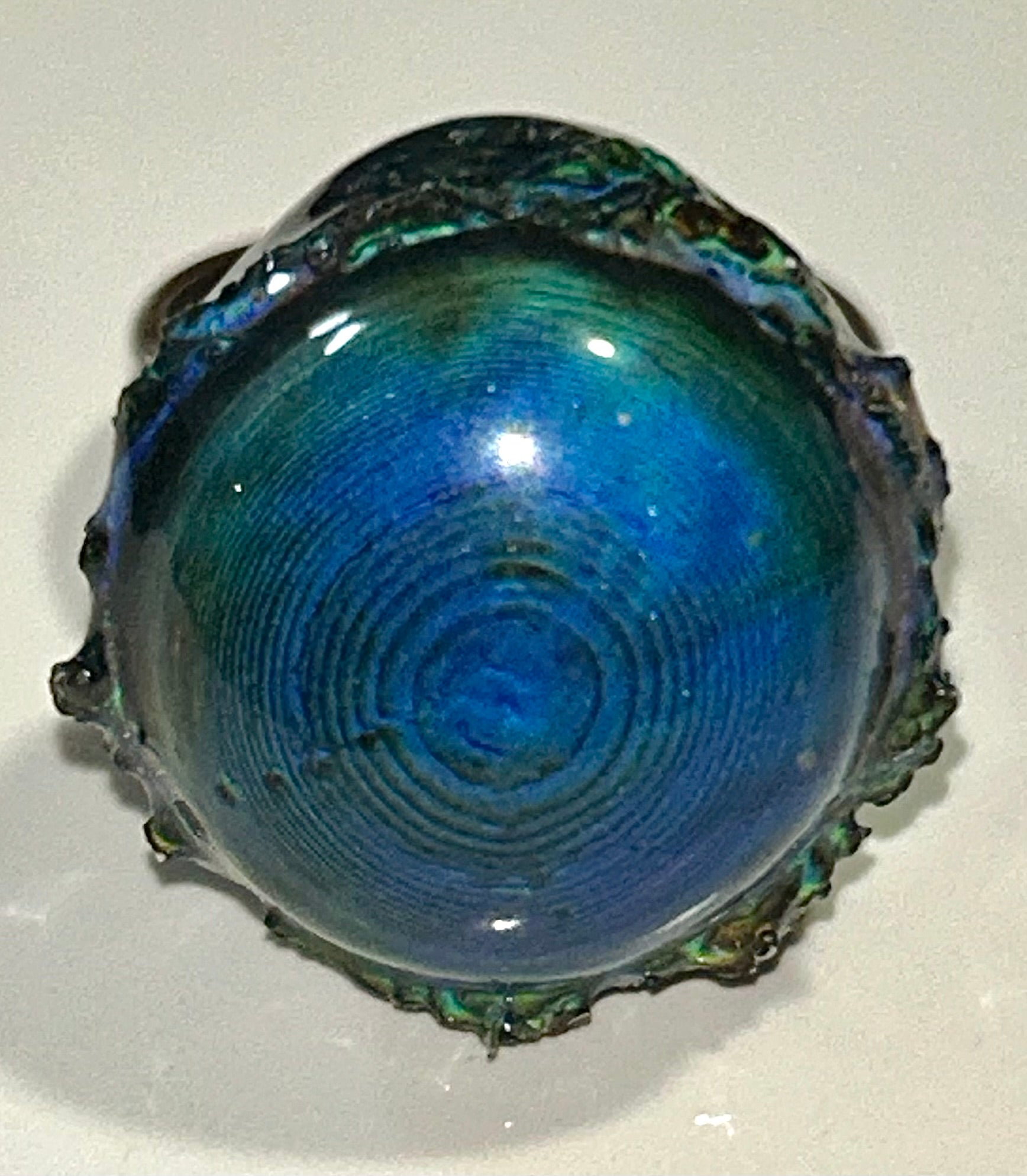 Bronze mood ring with a shiny, reflective surface on a white background