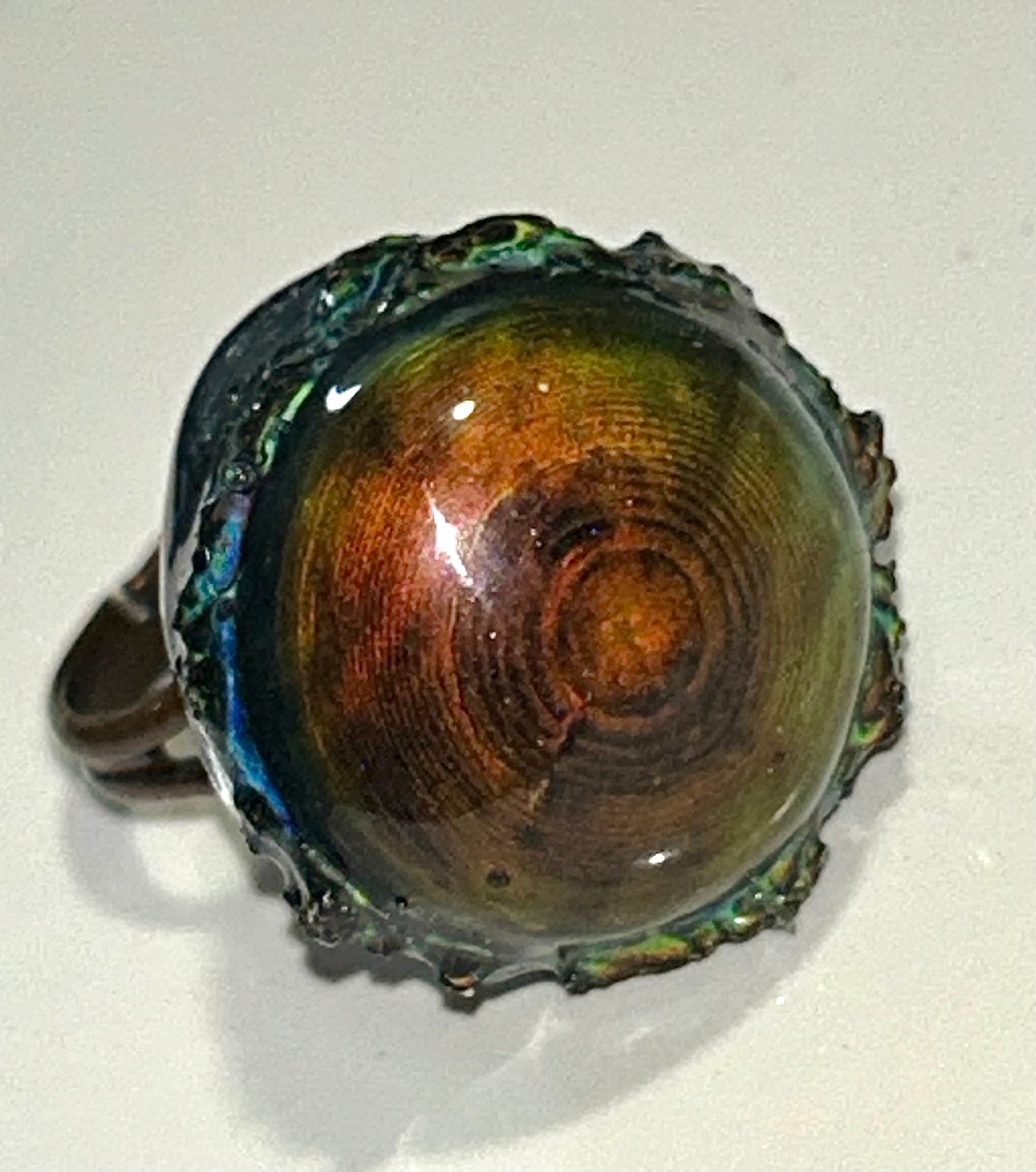 Bronze mood ring with a shiny, reflective surface on a white background