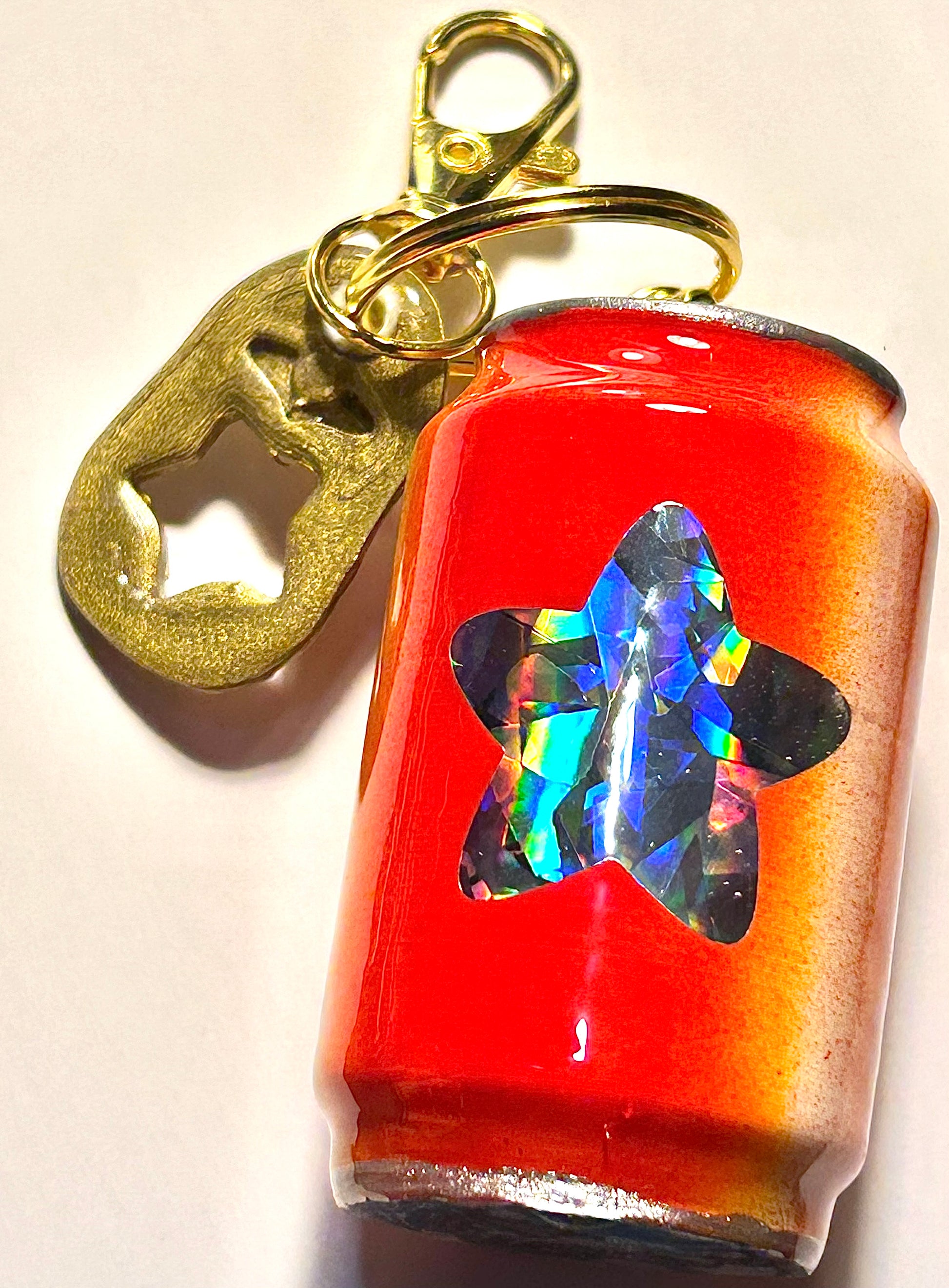 Keychain with a can-shaped soda and soda tab on a white background