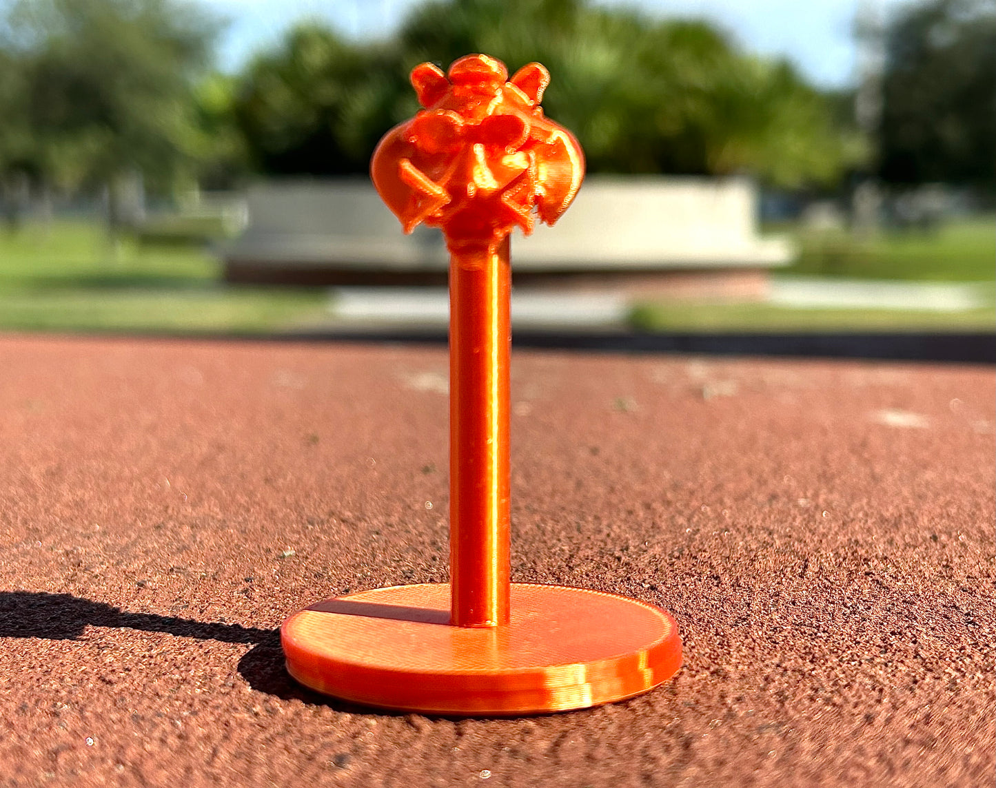 Orange Tiger figurine on a red surface outdoors