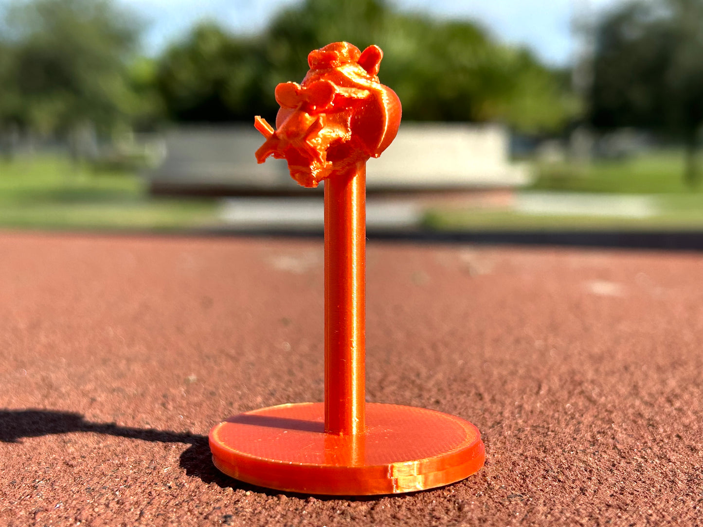 Orange Tiger figurine on a red surface outdoors
