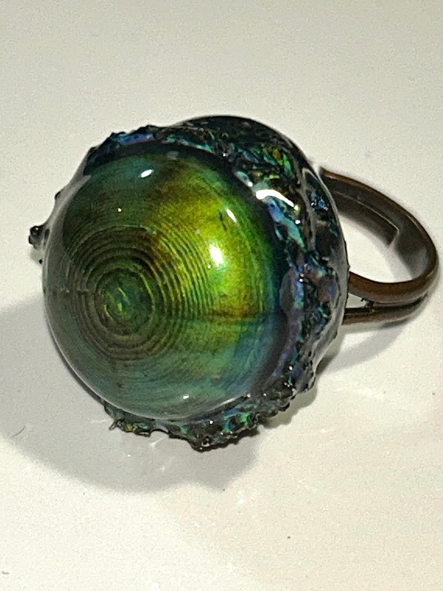 Bronze mood ring with a shiny, reflective surface on a white background