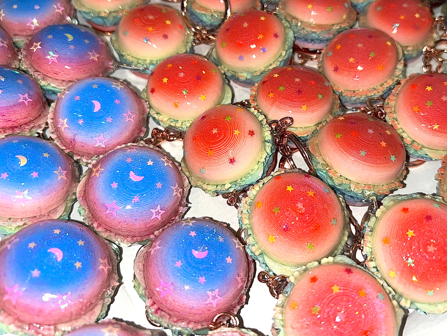 Colorful burger pastry keychains with star and moon designs on a white background