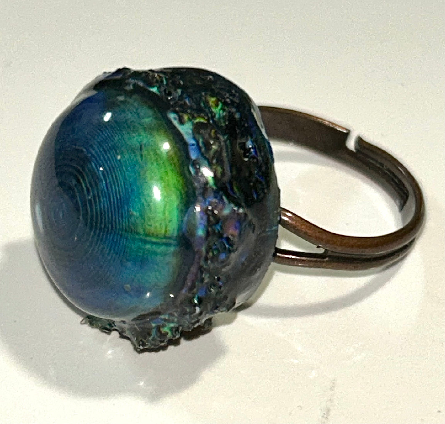 Bronze mood ring with a shiny, reflective surface on a white background