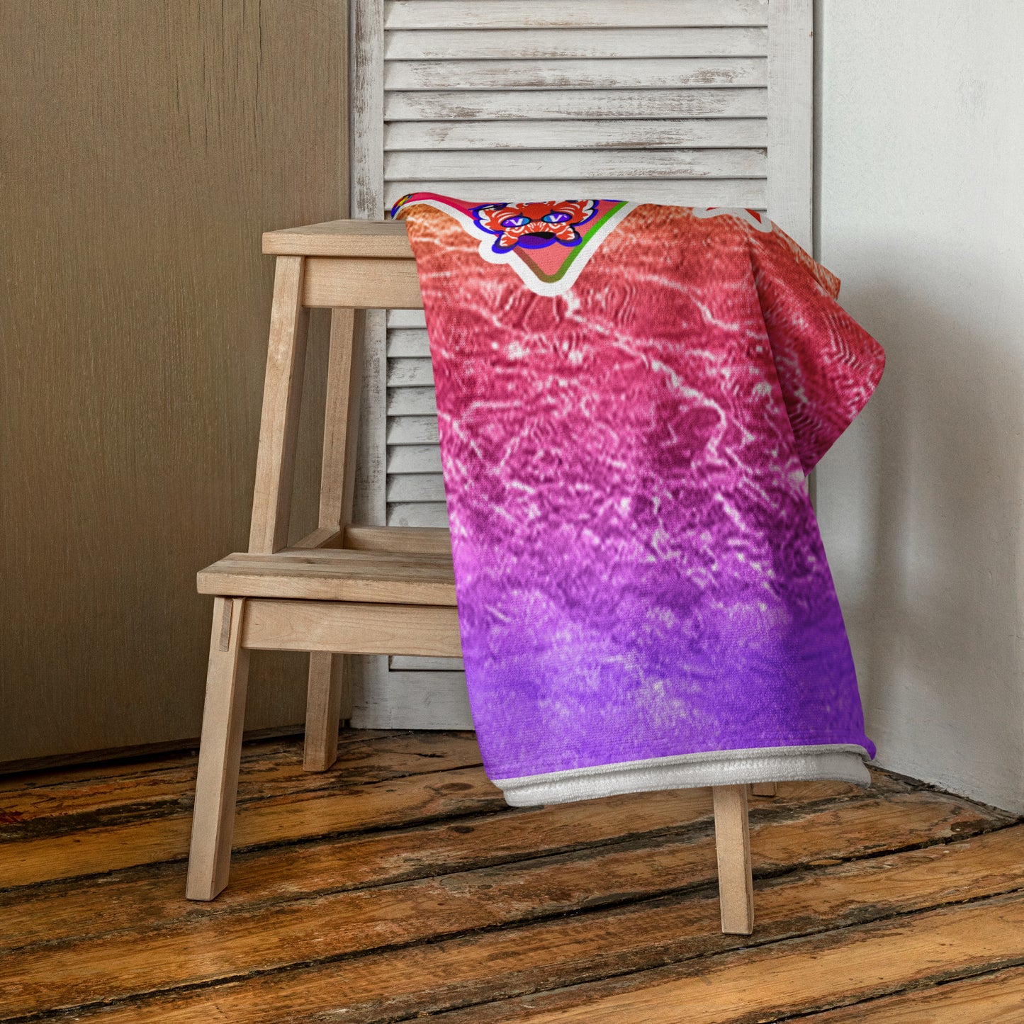 Colorful towel draped over a wooden chair on a wooden floor.