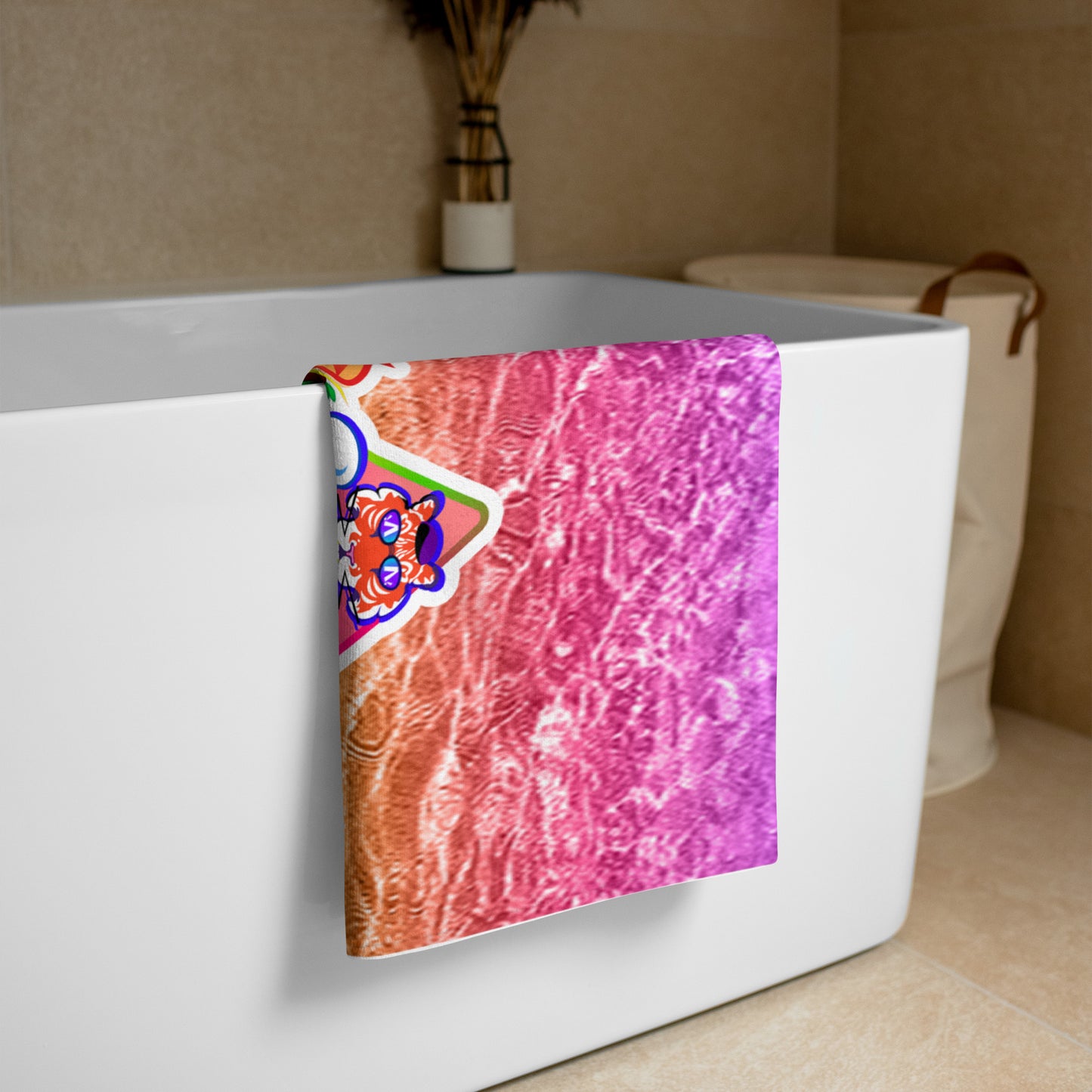 Bath towel with a colorful abstract design draped over a bathtub in a bathroom setting.