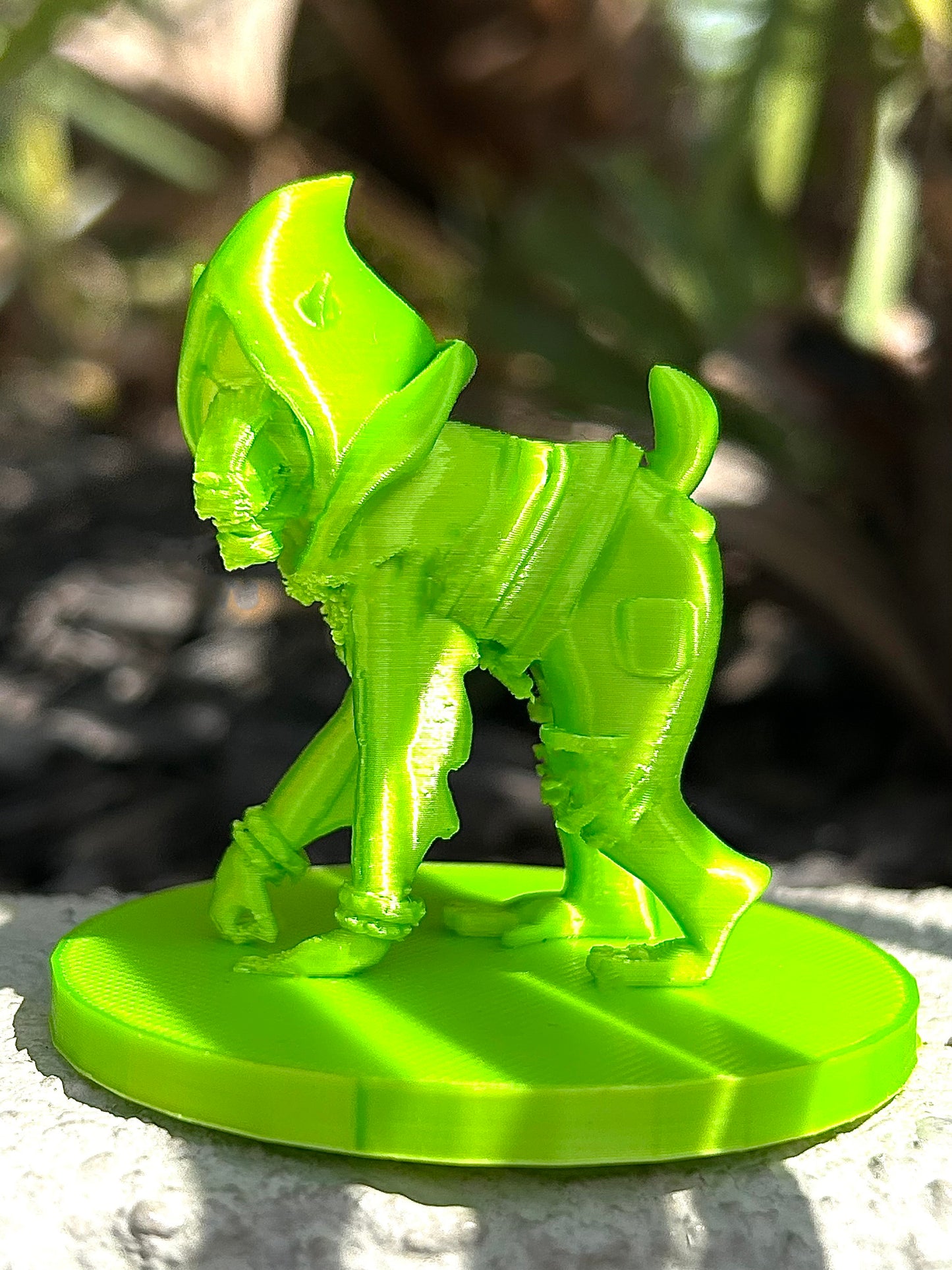 Green mandrill 3D modeled figurine against blurred natural environment