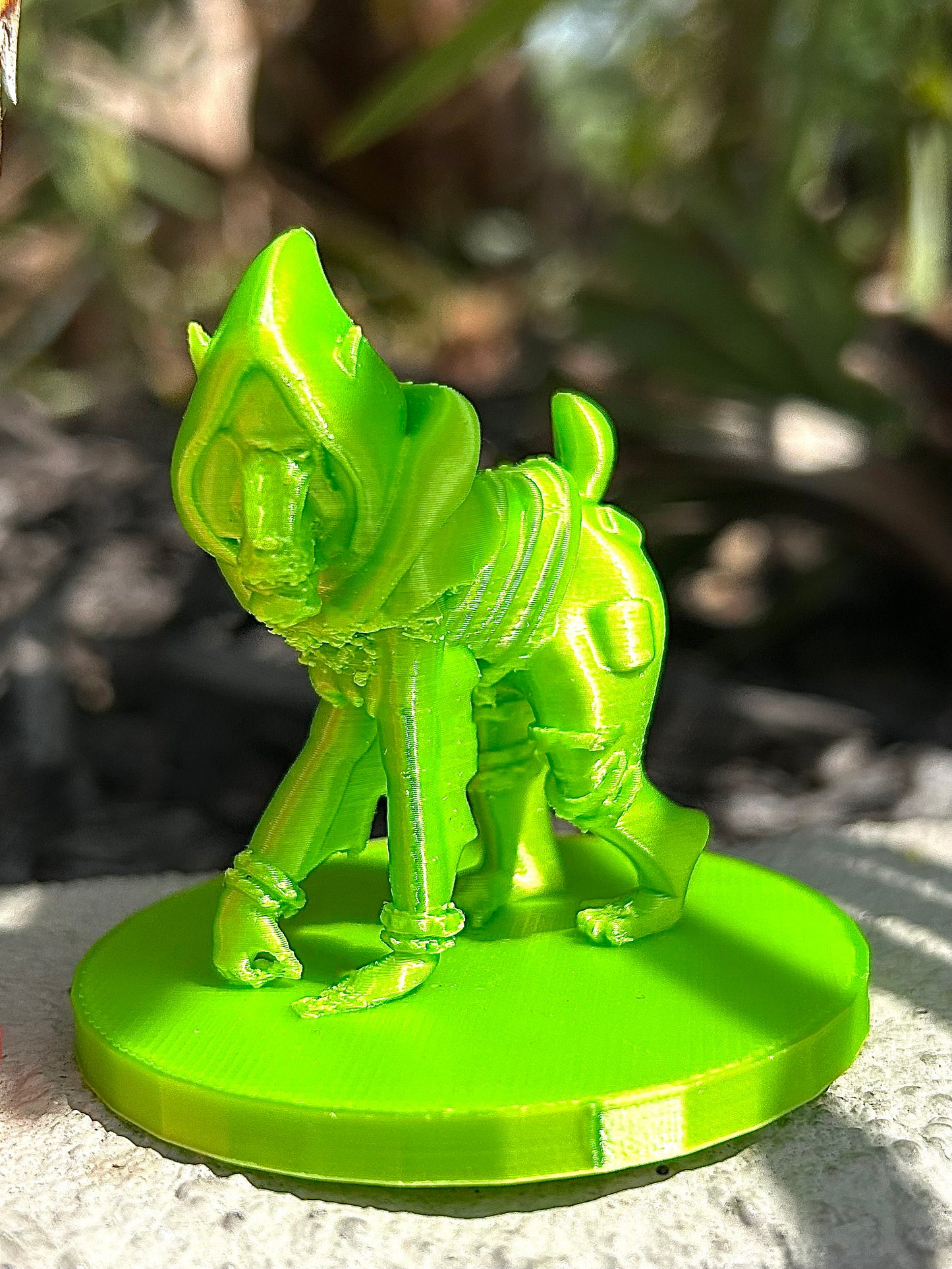 Green mandrill 3D modeled figurine against blurred natural environment