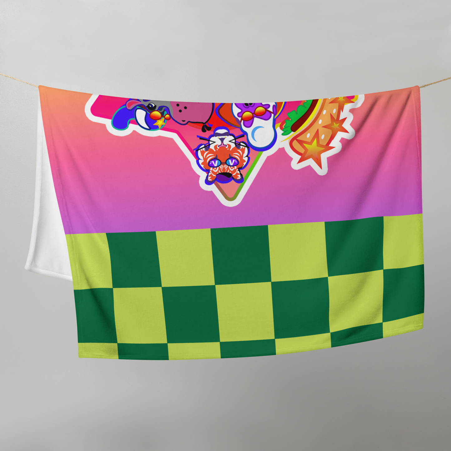 Colorful rainbow blanket with checkered tiles and cartoon character logo draped on a white background