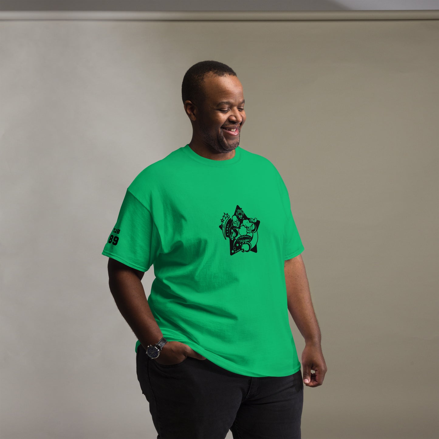 Man wearing a green t-shirt with a black graphic design on a plain background