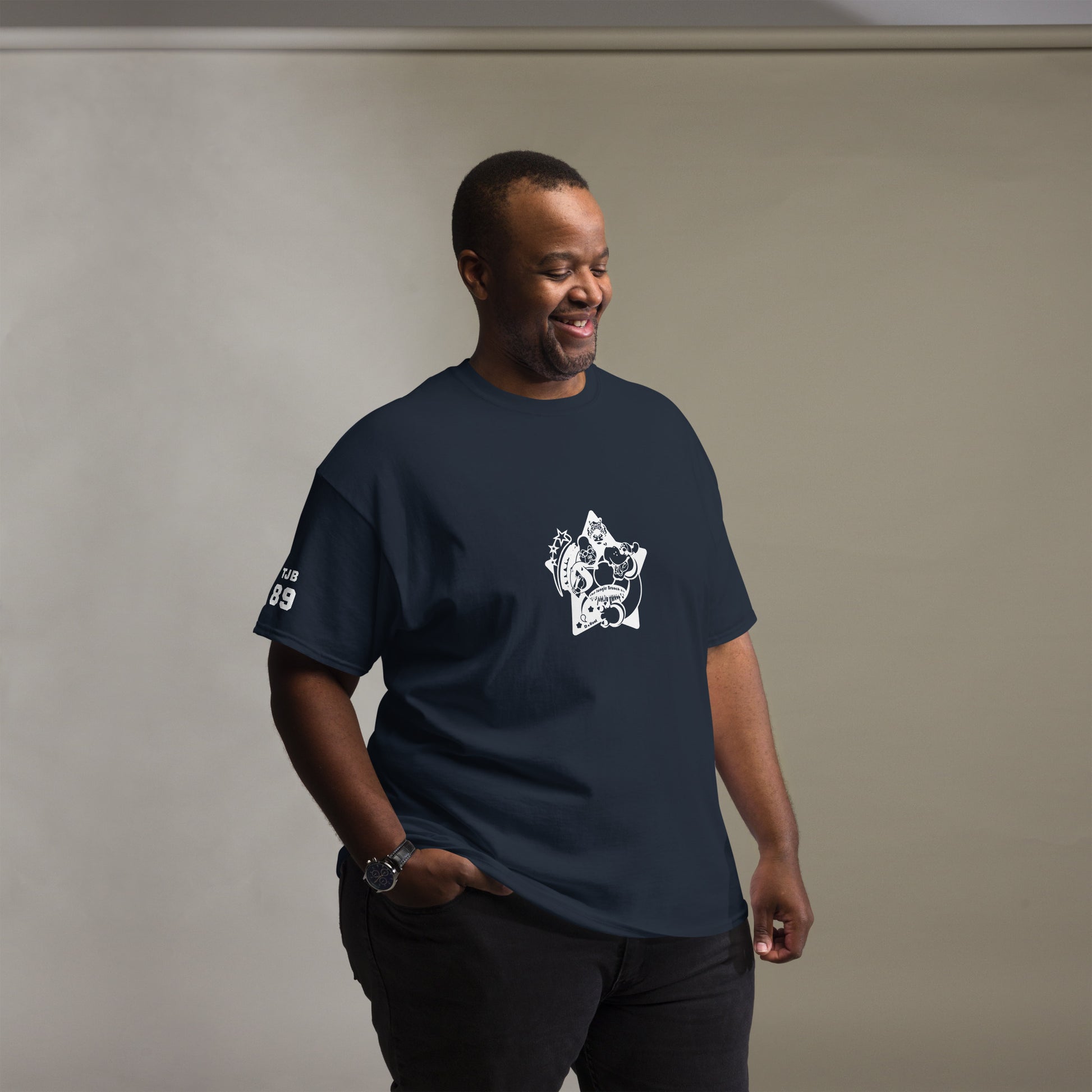 Man wearing a navy blue t-shirt with a white graphic design on a plain background